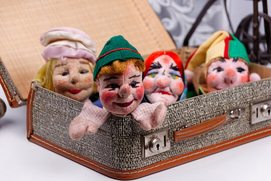 some punch puppets sitting inside a vintage suitcase
