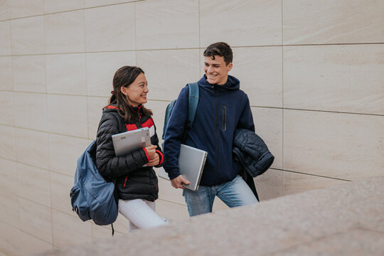 Cheerful students climbing up stairs together