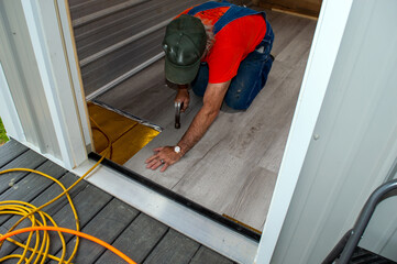Installation of gray laminate flooring in progress