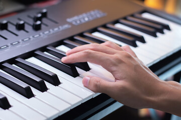 Hand on piano keyboard, playing music as a hobby, music playing concept