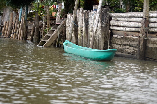 Boat moored by a seawall on the river bank near La Tola, Ecuador