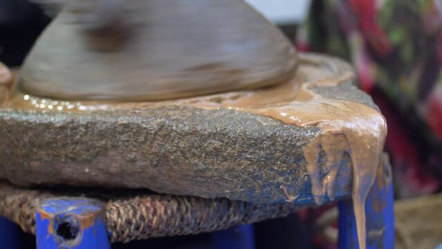 Berber Woman Grinds Argan Almonds in Stone Hand Mill Making Argan Oil in Morocco