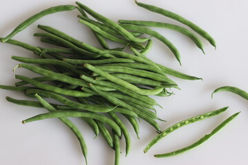 Bunch of French Beans shot on white back ground with few sliced half. It is also called green beans, bush beans, string beans, snap beans, haricot vert
