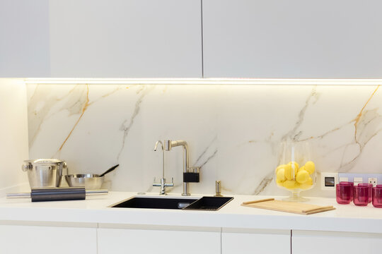 Modern white kitchen with marble walls