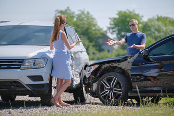Angry woman and man drivers of heavily damaged vehicles arguing who is guilty in car crash accident...