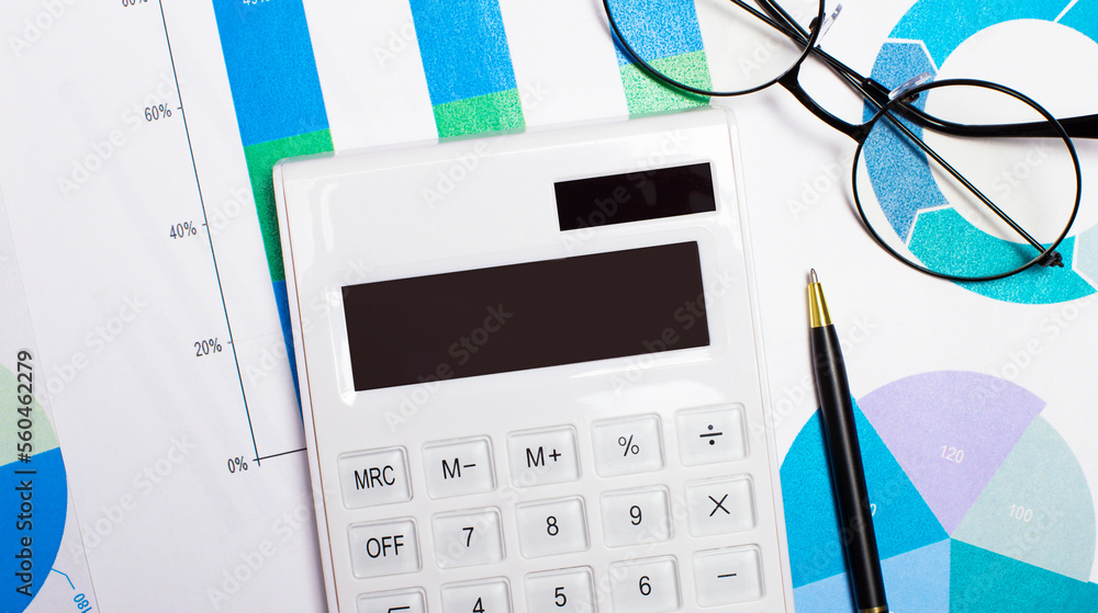 Poster on the desktop are reports, a pen, glasses and a white calculator with an empty table for inserting 