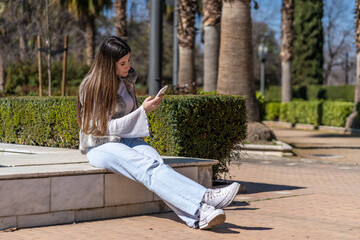 Caucasian woman with the phone sitting in a public park