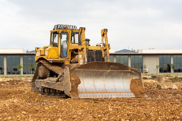 Dozer working at construction site. Bulldozer for land clearing, grading, utility trenching and...