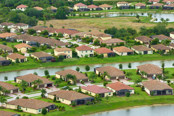 Fototapeta na wymiar View from above of densely built residential houses in closed living clubs in south Florida. American dream homes as example of real estate development in US suburbs