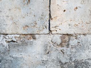 Close up photo of an abstract grunge texture of a stone brick cracked and weathered wall