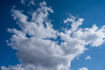 Naklejka na ściany i meble Cumulus clouds against the blue sky on a summer day.