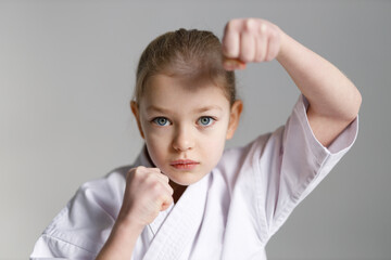 Fighting position for self-defense of a little girl in karate. Close-up, portrait.