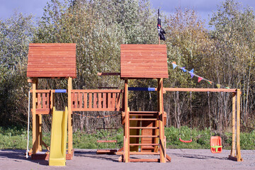 Fototapeta na wymiar Outdoor playset for toddlers and kids made of wood and plastic.