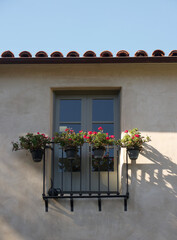 Fototapeta na wymiar romantic upper story balcony with geraniums hanging off the railing