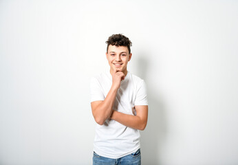 White t-shirt on teen boy. Handsome pensive caucasian isolated on a white background