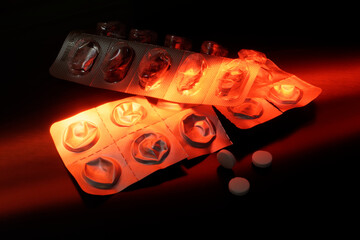 Two empty blister pack with pills, illuminated with red color