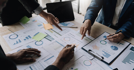 Business People Meeting using laptop computer,calculator,notebook,stock market chart paper for analysis Plans to improve quality next month. Conference Discussion Corporate Concept.