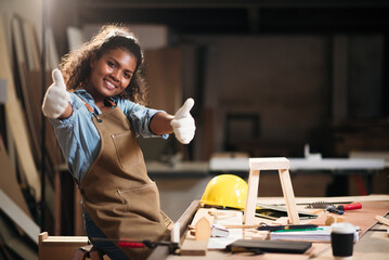 Young attractive black female carpenter  working  in small business workshop. Wood  industry and...