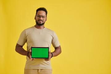 Portrait of joyful man showing digital tablet with green screen