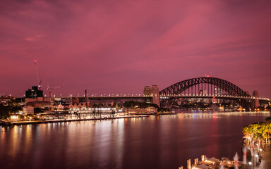 Fototapeta na wymiar Dramatic purple and pink sky as dawn breaks over Sydney Harbour Bridge and Circular Quay in Sydney