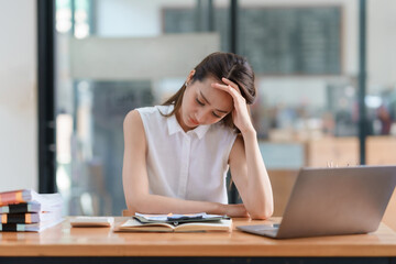 Asian businesswoman feeling tired and exhausted, headache stressed with overwork and unsuccessful work in the office.