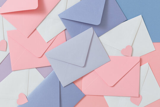 Full frame overhead view of assorted pastel coloured envelopes and heart shaped stickers