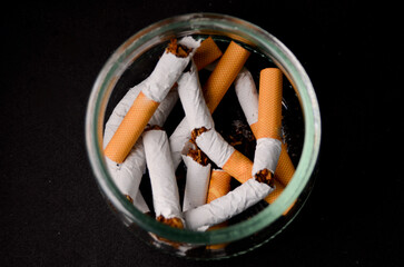 Give up smoking. Several broken cigars inside a glass ashtray. Anti-smoking campaign