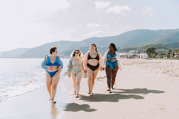 Group of beautiful plus size women with swimwear bonding and having fun at the beach - Group of...
