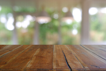Empty wooden table in front of abstract blurred Cafe, restaurant, house interior. For montage...