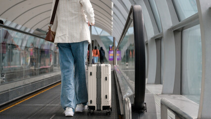 Close-up woman foot walking with suitcase , check in at International airport , vacation travel and transportation concept