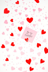 Valentine's Day background February 14th. Greeting card, engagement ring, paper hearts, confetti on white background.
