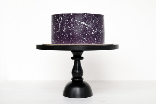 Cake with the image of the cosmos drawn by airbrush. Galaxy, stars in the night sky.