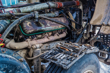A bunch of car keys on the background of a truck with an open engine.