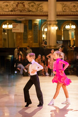 Attractive young couple of children dancing ballroom dance. Girl and boy dancer international dancing.