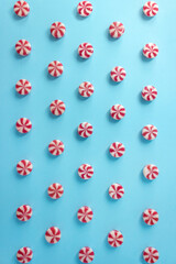 Red and white striped caramel candies on blue background. Vertical Christmas banner for candy shop