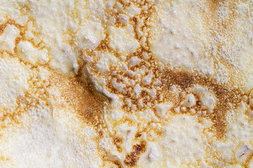 Pancake surface texture and pattern. Close-up of thin hot pancakes in a plate. Traditional rustic food. Graphic resource.