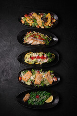 Five different kind of salad salad on a black concrete background
