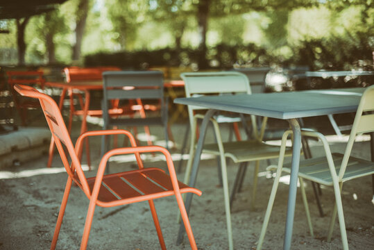 Close-up of metal tables and chairs in a park in summer, France