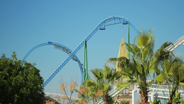 A trailer with people makes a dead loop on a roller coaster ride on a cloudless summer day. High quality 4k footage