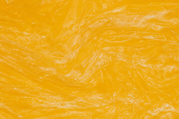 Crumpled wrinkled plastic transparent plastic cellophane wrapper on yellow color background....