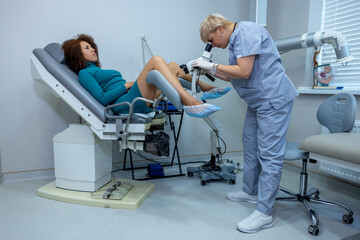 Experienced gynecologist doing colposcopy to a woman