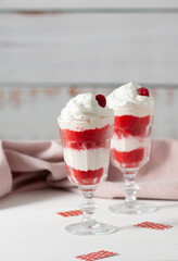Red velvet cake in glasses with white cream on a white background. A dessert for two lovers for Valentine's Day