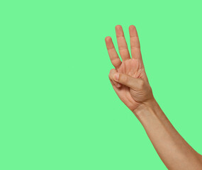 Three fingers raised up isolated on green screen background..