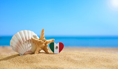 Fototapeta na wymiar Beautiful beach in Mexico. Flag of Mexico in the shape of a heart and shells on a sandy beach.