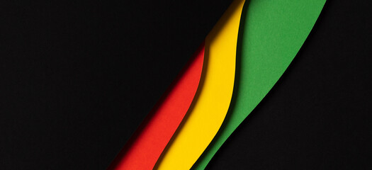 Black History Month color background. Abstract black, red, yellow, green color background with geometrical wavy lines and shapes. Top view