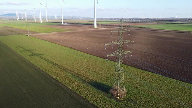 Power supply pole on farmland with powerlines and cables