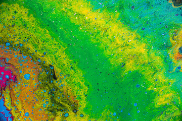 Mixture of liquid acrylic colors creating a marbled texture of bright, vibrant contrasting colors ideal for backgrounds and graphic design