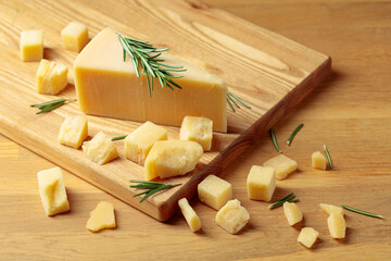 Parmesan cheese with rosemary  on a cutting board.