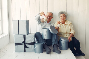 Elegant old couple sitting at home with christmas gifts