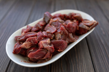 Diced and pickled raw boar meat in spices, soft focus